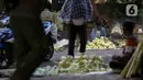 Pedagang musiman kulit ketupat menunggu pembeli di bawah kolong jembatan kawasan Pesanggrahan, Jakarta, Jumat (8/7/2021). Pedagang musiman memanfaatkan Idul Adha untuk berjualan kulit ketupat. (Liputan6.com/Johan Tallo)