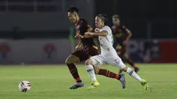 Pemain PSS Sleman, Kim Jeffrey Kurniawan (kanan) mengawal laju pemain PSM Makassar, Sutanto Tan yang sedang mengontrol bola pada laga perebutan juara tiga Piala Menpora 2021 di Stadion Manahan, Solo, Sabtu (24/4/2021). (Bola.com/M Iqbal Ichsan)