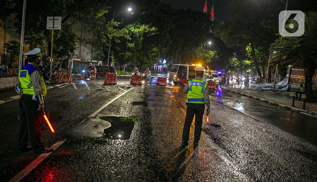 Polisi berjaga saat penyekatan jalan di kawasan Pasar Baru, Jakarta, Kamis (31/12/2020). Polda Metro Jaya menutup sejumlah ruas jalan selama Car Free Night dan Crowd Free Night pada malam Tahun Baru 2021 untuk mencegah penyebaran COVID-19. (Liputan6.com/Faizal Fanani)