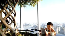 Seorang anak laki-laki membaca di Toko Buku Duoyun di Shanghai, China timur (16/8/2020). Terletak di Menara Shanghai lantai 52, Toko Buku Duoyun telah menarik banyak pengunjung untuk membaca dan menikmati panorama kota. (Xinhua/Zhang Jiansong)