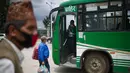 Calon penumpang bersiap naik bus di Kathmandu, Nepal (16/7/2020). Beberapa perusahaan angkutan umum di Lembah Kathmandu sudah mulai mengoperasikan kembali rute mereka untuk pertama kalinya dalam hampir empat bulan setelah menerima persyaratan operasional dari pemerintah. (Xinhua/Sulav Shrestha)