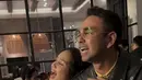 Nagita Slavina mengenakan t shirt putih dipadukan celana panjang motif ular abu-abu. Raffi mengenakan jaket kulit hitam.  [@shandypurnamasari]