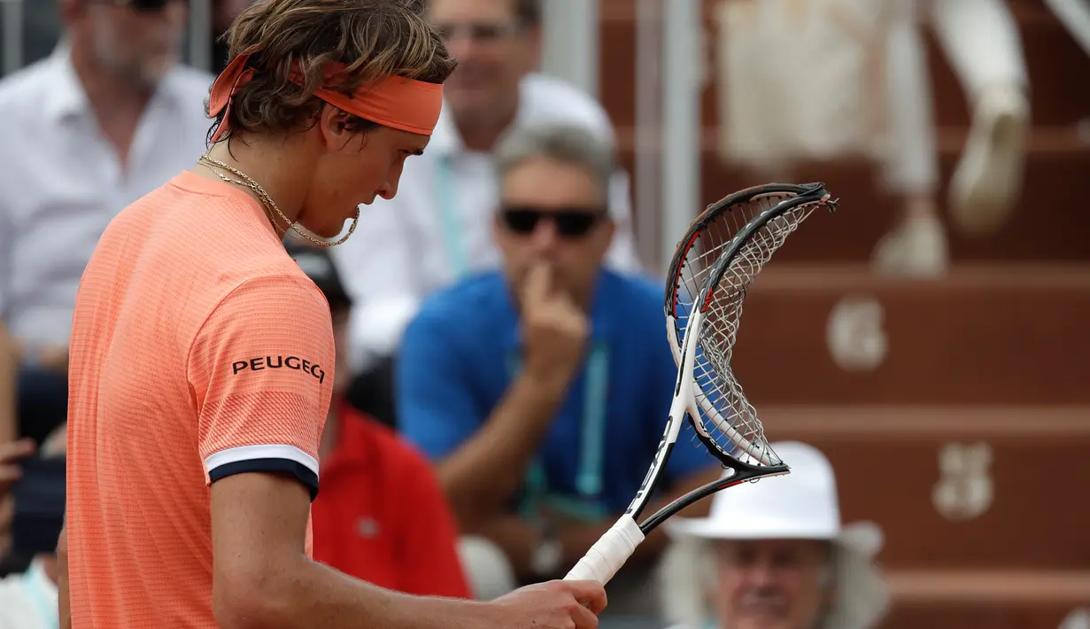 Petenis Jerman Alexander Zverev memegang raketnya yang baru saja ia rusak ketika melawan petenis Serbia Dusan Lajovic pada babak kedua Prancis Terbuka di Roland Garros, Rabu (30/5). Zverev harus melakoni lima set melawan Lajovic. (AP/Alessandra Tarantino)