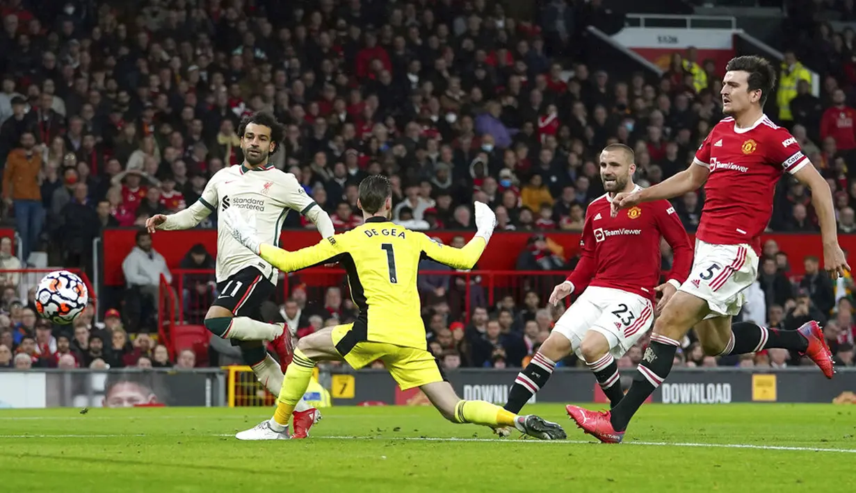 Pemain Liverpool Mohamed Salah (kiri) mencetak gol ke gawang Manchester United pada pertandingan Liga Inggris di Old Trafford, Manchester, Inggris, Minggu (24/10/2021). Liverpool menang 5-0. (Martin Rickett/PA via AP)