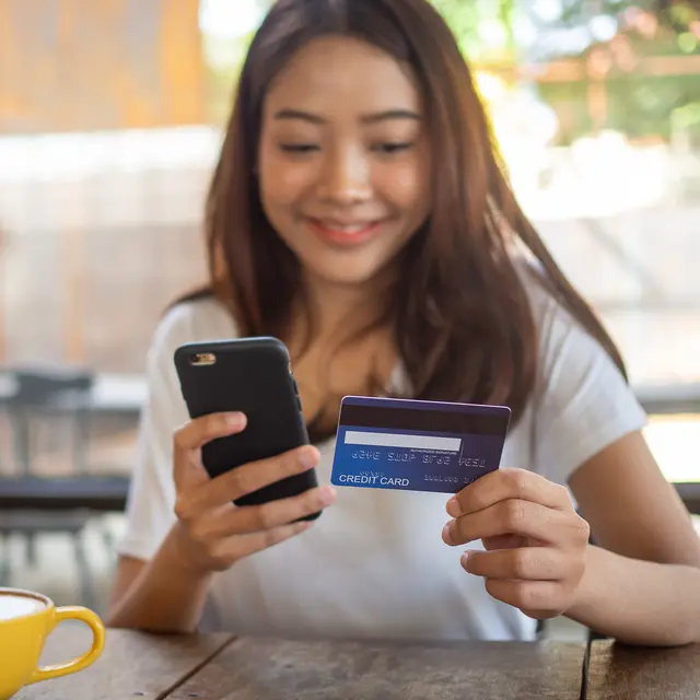 Seorang wanita belanja online dengan metode pembayaran menggunakan Debit BRI