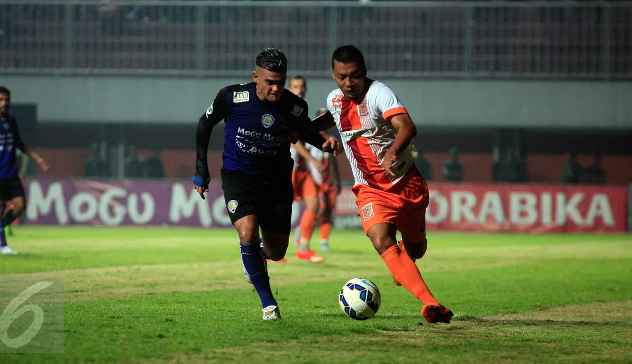 Pemain Persipura Ferinando Pahabol (bawah) berusaha mengambil bola dari pemain Surabaya United, M.Faturahman saat laga 8 besar Piala Jenderal Sudirman di Stadion Maguwoharjo, Sleman, Selasa (22/12/2015). Persipura menang 2-0. (Foto: Boy Harjanto)
