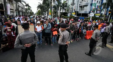 Petugas kepolisian menjaga ketat jalan yang dilalui Para kepala Negara dan delegasi dari Asia dan Afrika mengikuti 'Historical Walk' dalam rangkaian Peringatan KAA ke-60, di Jalan Asia Afrika, Bandung, Jumat (24/4/2015). (Liputan6.com/Faizal Fanani)