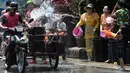 Warga menghujani pengendara sepeda motor dengan air saat merayakan Festival Songkran atau Tahun Baru Thailand di Narathiwat, Thailand, 13 April 2019. Festival ini rutin diselenggarakan setiap tanggal 13-15 April setiap tahunnya. (Madaree TOHLALA/AFP)
