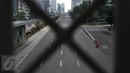 Sebuah taksi melintasi jalan protokol yang lengang di kawasan MH Thamrin, Jakarta, Selasa (6/7). Hampir semua jalan di Ibu Kota lengang saat sebagian besar warga mudik untuk merayakan Lebaran di kampung halaman. (Liputan6.com/Faizal Fanani)
