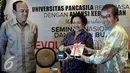 Ketua Umum PDIP Megawati Soekarnoputri menerima cinderamata dari Yudi Latif disaksikan Siswono Yudo Husodo (kiri) saat hadiri dalam seminar nasional dan bedah buku Revolusi Pancasila di Jakarta, Selasa (27/10). (Liputan6.com/Johan Tallo)