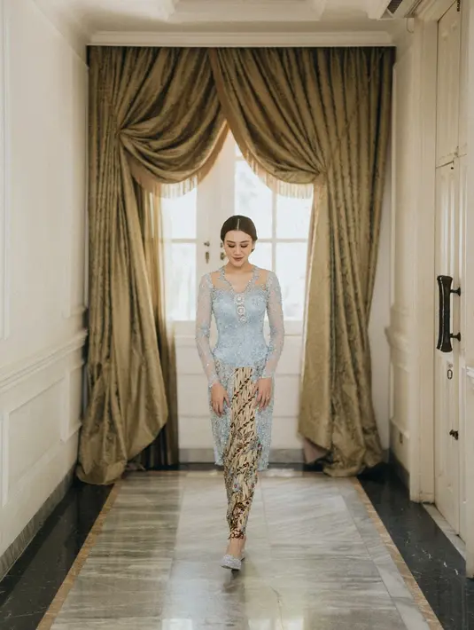 Cantiknya Aaliyah Massaid dibalut kebaya biru di prosesi Lamarannya dengan Thariq Halilintar. Kebaya kutu baru berwarna biru muda yang dipenuhi payet dan diberi pemanis berupa bros perak di bagian tengah dada sangat apik membalut tubuhnya. Ditambah padu padan kain batik cokelat muda dengan sentuhan warna biru sebagai rok juga terlihat menyempurnakan keseluruhan penampilan Aaliyah di sini. [Foto: Instagram/morden.co]