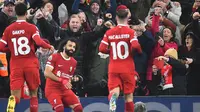 Dua pemain Liverpool, Cody Gakpo dan Alexis Mac Allister, berlari menghampiri Mohamed Salah yang baru saja mencetak gol ke gawang Newcastle United dalam laga pekan ke-20 Liga Inggris 2023/2024 di Anfield, Selasa (2/1/2024) dini hari WIB. Liverpool menang 4-2 atas Newcastle United dalam laga ini. (PETER POWELL / AFP)