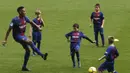 Yerry Mina beraksi dengan bermain bola bersama anak-anak akademi Barcelona di Camp Nou stadium, Barcelona, (13/1/2018). Mina didatangkan Barcelona dari Palmeiras sebesar 10.5 juta pounds. (AP/Manu Fernandez)