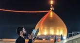 Seorang Muslim Syiah membaca Al-Quran, saat melaksanakan Itikaf di Masjid Kufa, selatan Baghdad, Irak, pada 12 Maret 2026. (Qassem al-KAABI/AFP)
