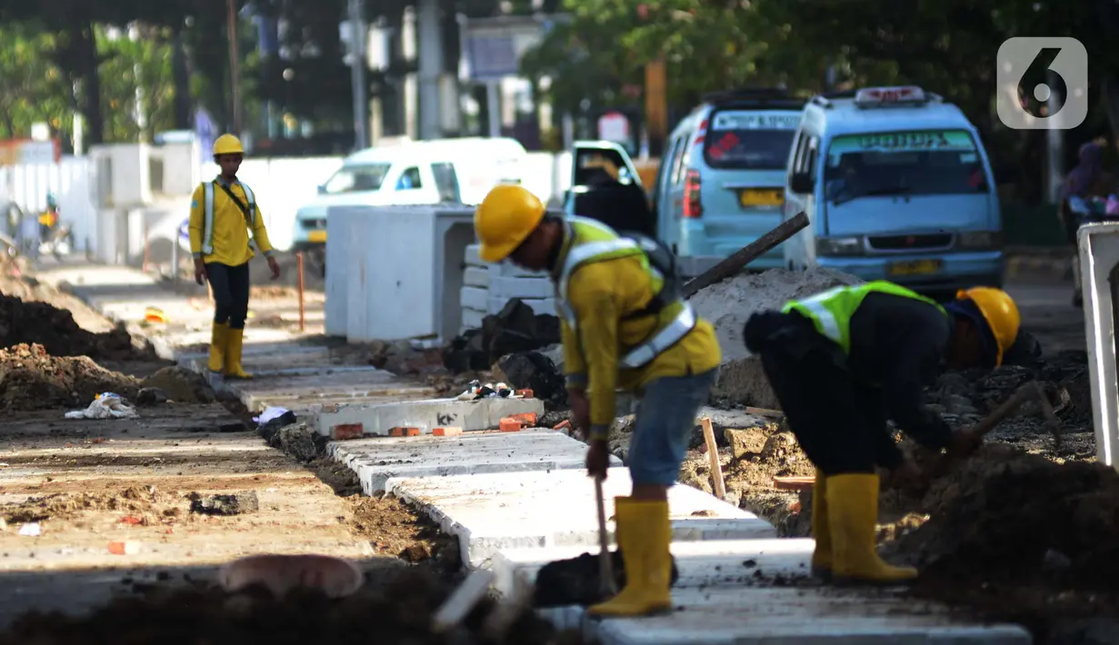 Pekerja menyeselasikan proyek revitalisasi kawasan Kota Tua, Jakarta, Rabu (23/3/2022). Revitalisasi pedestrian ini nantinya akan menjadi plaza pedestrian yang lebar sebagai bentuk penataan kawasan Kota Tua yang rendah emisi dan destinasi pariwisata bersejarah. (merdeka.com/Imam Buhori)