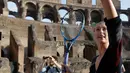 Petenis asal Rusia, Maria Sharapova bersiap memukul bola saat mengunjungi Colosseum, Roma, Italia (14/5). Sharapova sebelumnya terkena hukuman larangan bertanding akibat terjerat kasus doping. (AP Photo / Gregorio Borgia)
