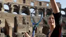 Petenis asal Rusia, Maria Sharapova bersiap memukul bola saat mengunjungi Colosseum, Roma, Italia (14/5). Sharapova sebelumnya terkena hukuman larangan bertanding akibat terjerat kasus doping. (AP Photo / Gregorio Borgia)