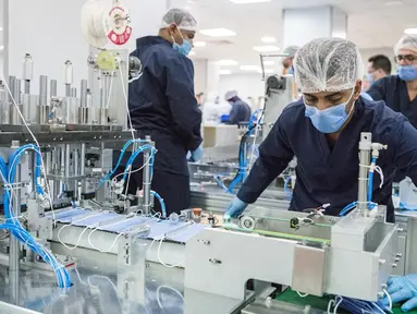 Orang-orang bekerja di sebuah pabrik yang memproduksi masker medis di Kairo, Mesir, 14 April 2020. Para karyawan bekerja siang dan malam untuk mengoperasikan lima mesin canggih yang dibawa dari China untuk memproduksi hingga 750.000 masker medis per hari. (Xinhua/Wu Huiwo)