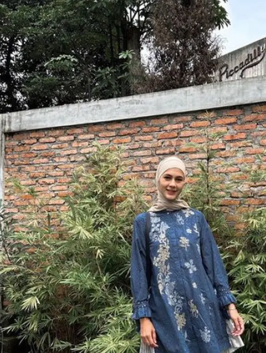 Paula Verhoeven mengenakan tunik biru bermotif dipadukan kerudung coklat muda serta celana panjang hitam loose. Serta mengenakan sneakers putih. [@paula_verhoeven]