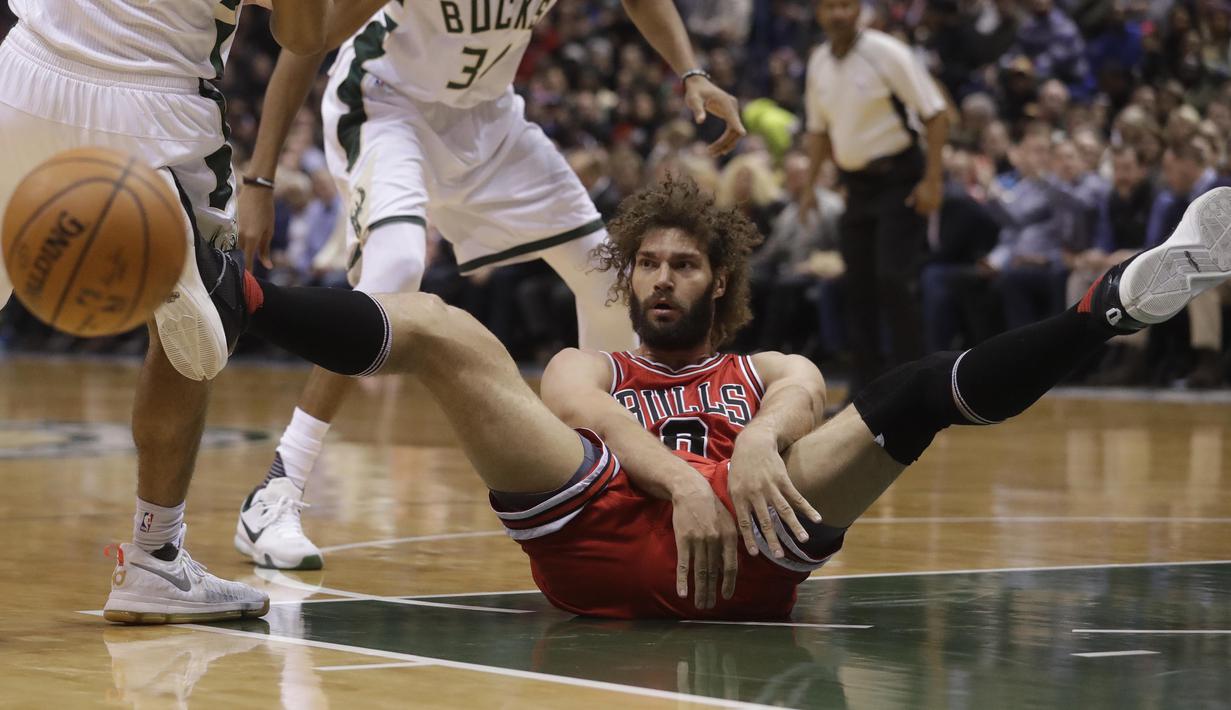 Pemain Chicago Bulls, Robin Lopez terjatuh saat berebut bola dengan pemain Milwaukee Bucks pada lanjutan NBA di BMO Harris Bradley Center, (15/12/2016). Bucks menang 108-97.  (AP/Morry Gash)