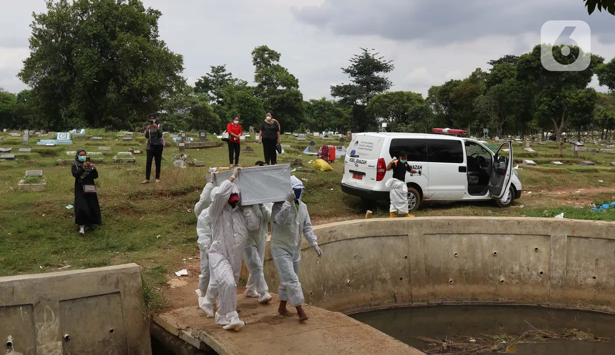 Petugas membawa peti jenazah yang akan dimakamkan dengan protokol COVID-19 di area khusus TPU Srengseng Sawah, Jakarta, Kamis (14/1/2021). TPU Srengseng Sawah mulai menerima pemakaman jenazah dengan protokol COVID-19 sejak Selasa (12/1) lalu. (Liputan6.com/Helmi Fithriansyah)