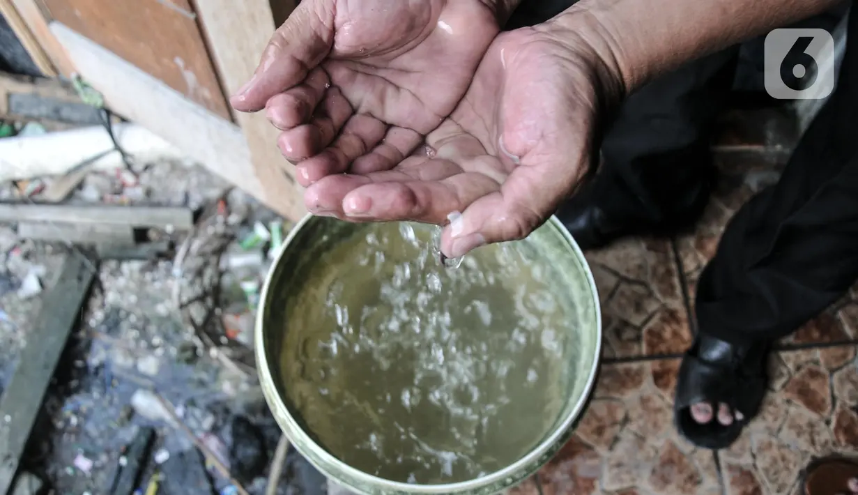 Warga menunjukkan kondisi air sumur yang keruh di kampung nelayan Kalibaru, Cilincing, Jakarta Utara, Selasa (22/3/2022). Hingga kini air pikulan masih menjadi kebutuhan utama warga di kawasan pesisir Cilincing untuk keperluan konsumsi akibat air sumur keruh dan bau. (merdeka.com/Iqbal S Nugroho)