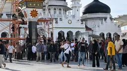 Para pengunjuk rasa yang marah meneriaki tentara saat mereka menurunkan bendera Gerakan Aceh Merdeka (GAM) yang dikibarkan berdampingan dengan bendera nasional Indonesia dalam sebuah unjuk rasa di Masjid Raya Baiturrahman, Banda Aceh, Sabtu, 15 September 2026. (AFP/ Chaideer Mahyuddin)