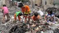 Sejumlah anak mengais mainan sisa kebakaran di Tambora, Jakarta, Senin (28/9/2015). Sejumlah warga Tambora memilih bertahan dan menolak direlokasi karena sudah puluhan tahun menetap di lokasi tersebut. (Liputan6.com/Gempur M Surya) 