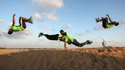 Empat pemuda Palestina melakukan aksi keterampilan parkour di dekat tenda warga di perbatasan Gaza, Palestina (10/4). Sebelumnya sejumlah warga membangun tenda di perbatasan Gaza untuk meminta hak tanah mereka atas Isreal. (AFP Photo/Said Khatib)