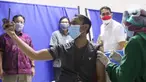 Warga mengabadikan momen saat vaksinasi covid-19 di sentra vaksin Tomang Tol Plaza, Tangerang, Sabtu (24/7/2021). Pemerintah sebelumnya menetapkan target sasaran vaksinasi 181,5 juta atau 70 persen dari total populasi untuk mencapai kekebalan kelompok atau herd immunity. (Liputan6.com/Angga Yuniar)