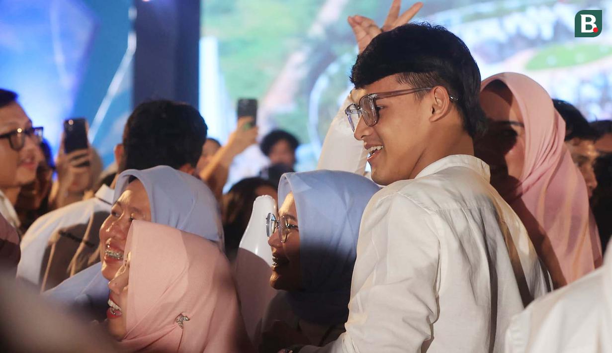 Atlet atlet angkat besi, Rizki Juniansyah berfoto bersama dengan para penonton dalam acara apresiasi kepada atlet peraih medali Olimpiade 2024 di Pos Bloc, Jakarta, Senin (2/9/2024). (Bola.com/M. Iqbal Ichsan)