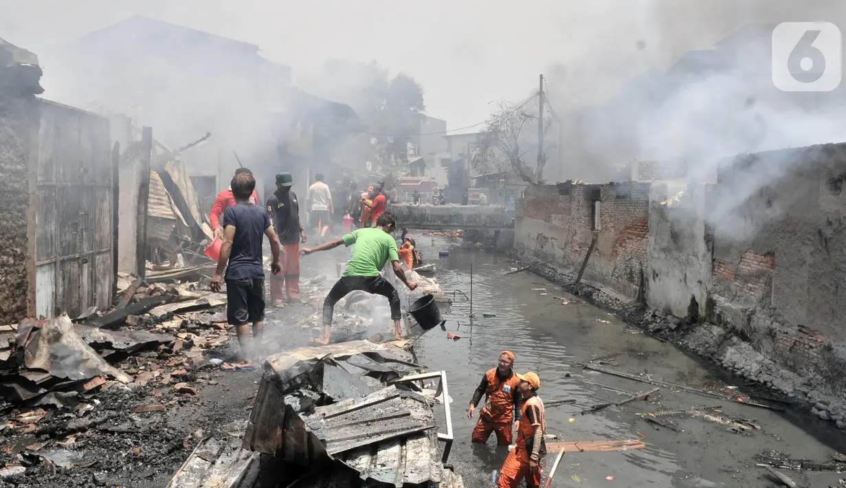 Warga bergotong royong mengambil air dari kali saat berusaha menjinakkan kebakaran di Jalan Kebon Jeruk 13, Taman Sari, Jakarta Barat, Minggu (6/10/2019). Kebakaran diduga akibat anak bermain korek api. (merdeka.com/Iqbal Nugroho)