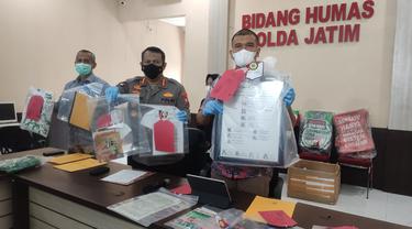 Polda Jatim menunjukkan sejumlah barang bukti sitaan dari Khilafatul Muslimin Surabaya Raya. (Dian Kurniawan/Liputan6.com).