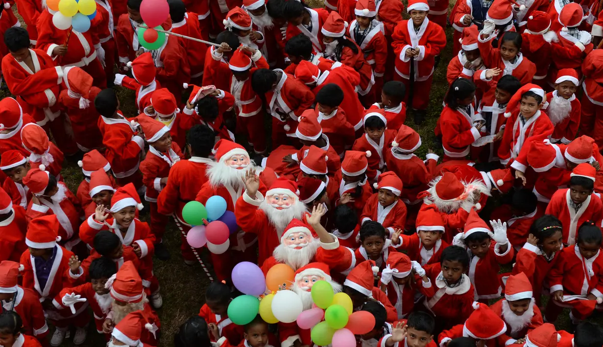 Anak-anak sekolah India mengenakan kostum Santa Claus berpose saat mereka mengambil bagian dalam acara Natal di sebuah sekolah di Chennai, (5/12). Natal adalah hari raya umat Kristen yang diperingati setiap tanggal 25 Desember. (AFP Photo/Arun Sankar)
