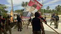 Penurunan baliho Bupati Kabupaten Muna Barat yang dipasang di Kabupaten Muna karena dinilai provokatif.(Liputan6.com/Ahmad Akbar Fua)