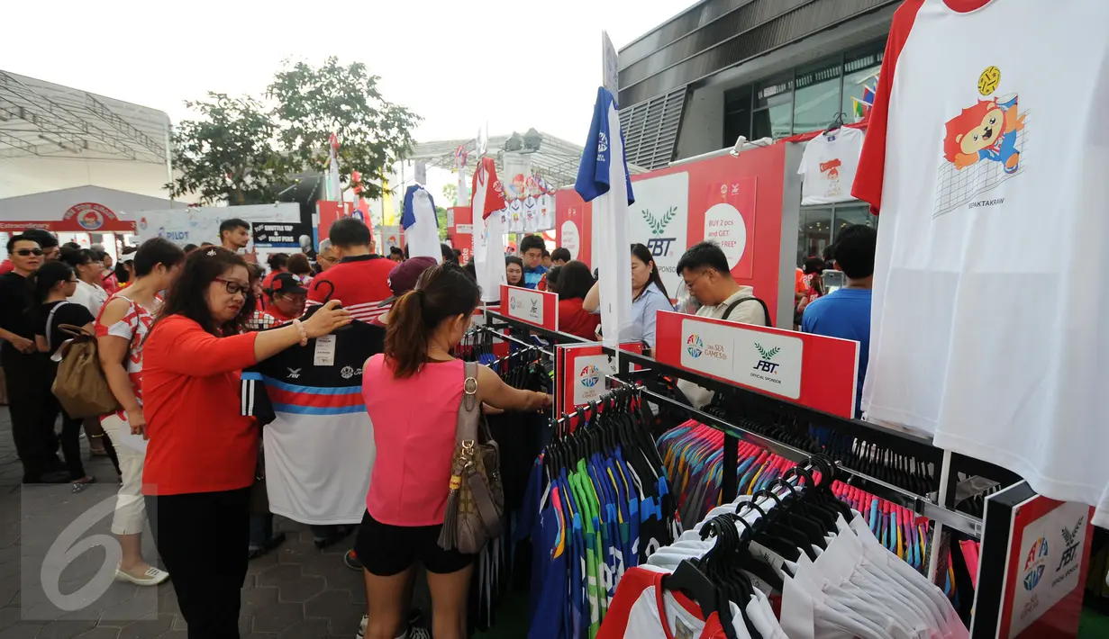 Ribuan warga, baik domestik maupun manca negara mendatangi lokasi pembukaan SEA Games 2015 di National Stadium Singapura, Jumat (5/6/2015). Sambil menunggu waktu, beberapa warga terlihat memilih souvenir SEA Games 2015. (Liputan6.com/Helmi Fithriansyah)