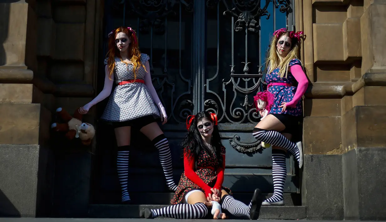 Peserta berpose dengan kostum dan dandanan menyerupai zombie selama acara Zombie Walk di Sao Paulo, Brasil, Sabtu (2/11/2019). Ratusan orang turun ke jalan memakai kostum karakter horor pada acara tahunan yang digelar sejak 2006 pada Hari Para Arwah. (Miguel SCHINCARIOL / AFP)
