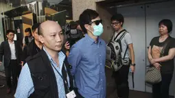 Polisi Hong Kong mengamankan seorang staff saat razia di kantor Uber Inc, Selasa (11/8/2015). Dalam razia ini polisi mengamankan 5 orang yang tertangkap basah memberikan jasa pelayanan sebagai sopir taxi dengan kendaraan ilegal. (REUTERS/Apple Daily)