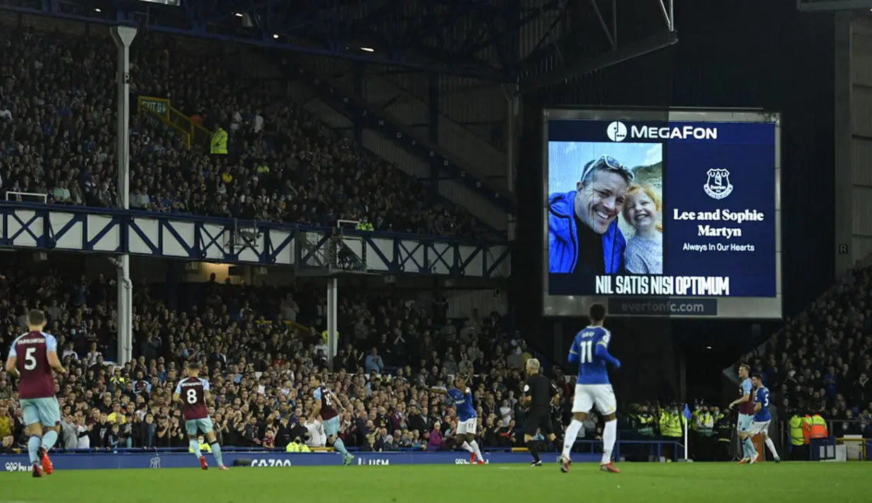 Pemain Everton Lee Martyn dan putrinya Sophie yang tewas secara tragis dalam penembakan di Plymouth bulan lalu ditampilkan pada layar lebar saat menit ke-43 pertandingan Liga Inggris antara Everton dan Burnley di Goodison Park, Liverpool, Inggris, 13 September 2021. (Oli SCARFF/AFP)
