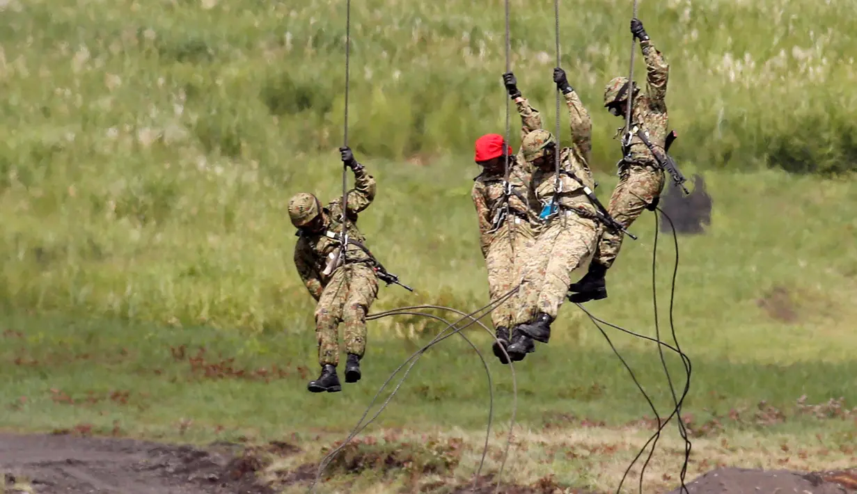 Tentara Self-Defense Force Jepang turun dari helikopter menggunakan tali selama sesi latihan tahunan di dekat Gunung Fuji di lapangan pelatihan Higashifuji di Gotemba, Tokyo, (25/08). (REUTERS / Kim Kyung-Hoon)