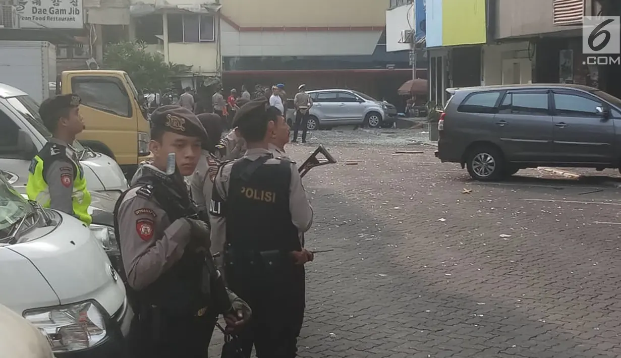 Anggota polisi bersenjata lengkap berjaga di lokasi ledakan di kawasan Ruko Grand Wijaya, Kebayoran Baru, Jakarta Selatan, Kamis (12/7). Sumber ledakan berasal dari lantai satu sebuah kantor konsultan hukum. (Liputan6.com/Ady Anugrahadi)