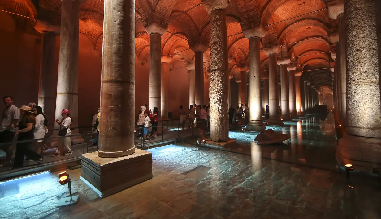 <p>Pengunjung berjalan melewati kolom Medusa di Basilika Cistern era Bizantium di Istanbul, Turki, Rabu, 27 Juli 2022. Meski dulunya dikenal sebagai tempat penampungan air, namun saat ini hanya dapat ditemukan beberapa tempat dengan kolam yang terisi dengan air. (AP Photo/Emrah Gurel)</p>