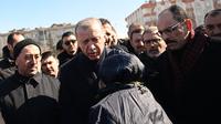 Presiden Turki Recep Tayyip Erdogan bertemu dengan penduduk yang mengungsi di bawah tenda yang didirikan pemerintah selama kunjungannya ke kota Kahramanmaras di tenggara Turki, dua hari setelah gempa kuat melanda wilayah tersebut, pada 8 Februari 2023. Warga masih banyak yang mengungsi takut terjadi gempa susulan. (AFP/Ozan Kose)