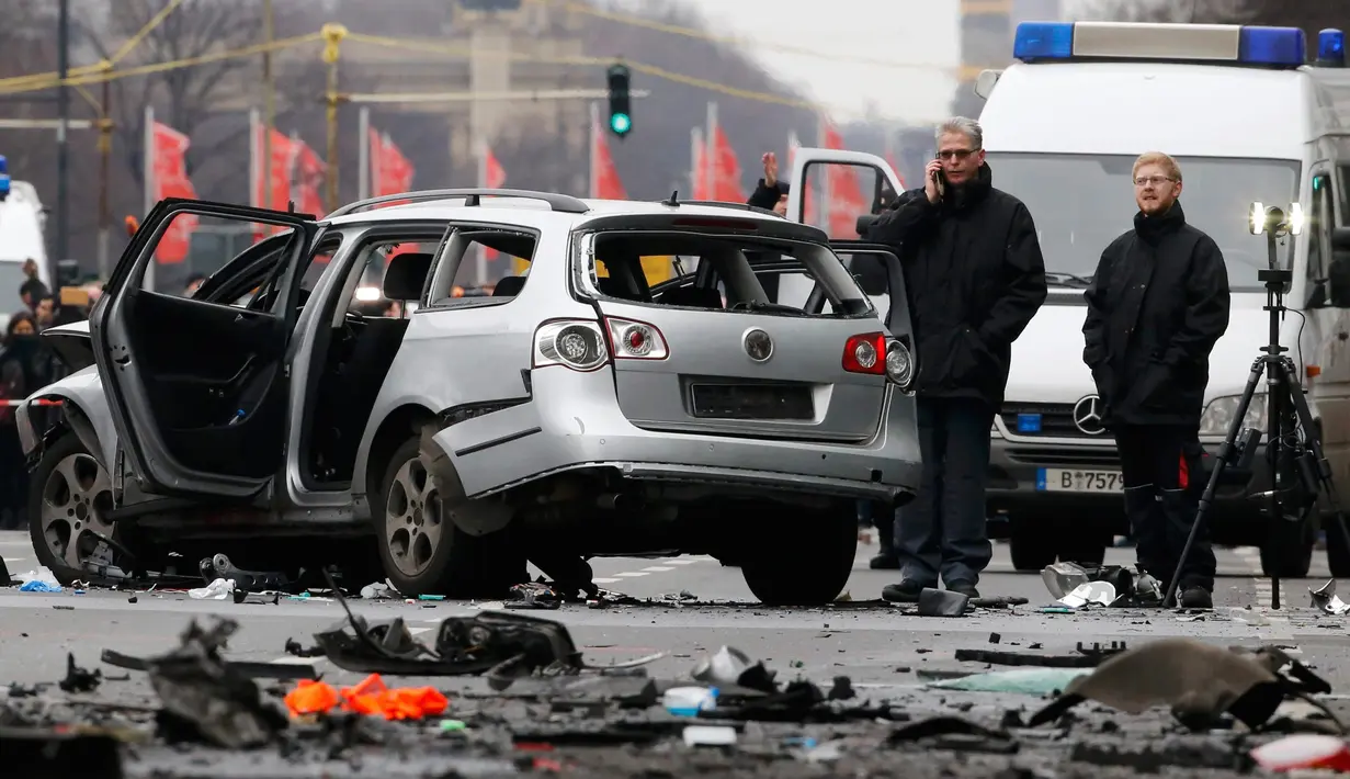 Petugas kepolisian memeriksa bangkai mobil Volkswagen yang rusak di Berlin , Jerman, (15/3). Warga Jerman di gegerkan oleh sebuah mobil yang tiba meledak di pusat kota Berlin. (REUTERS / Fabrizio Bensch)