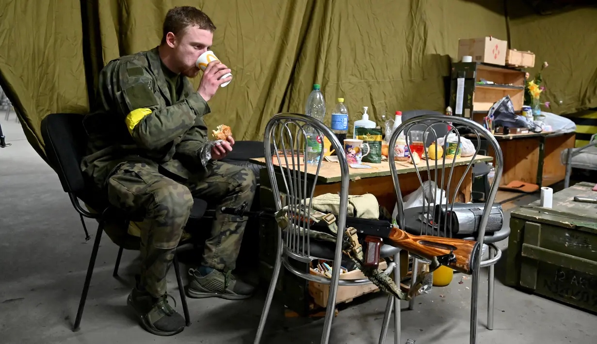 Pasukan Pertahanan Teritorial Ukraina, cadangan militer Angkatan Bersenjata Ukraina, makan siang di garasi bawah tanah yang telah diubah menjadi pangkalan pelatihan dan logistik di Kiev, pada Jumat (11/3/2022). (Sergei SUPINSKY / AFP)