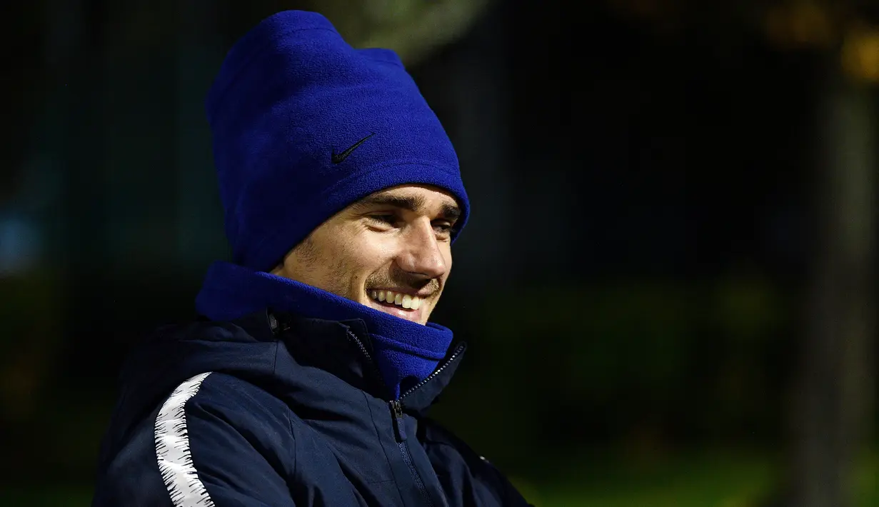 Striker timnas Prancis, Antoine Griezmann tersenyum saat menghadiri sesi latihan Clairefontaine-en-Yvelines (12/11).  Prancis juga akan bertanding pada pertandingan persahabatan melawan timnas Uruguay. (AFP Photo/Franck Fife)