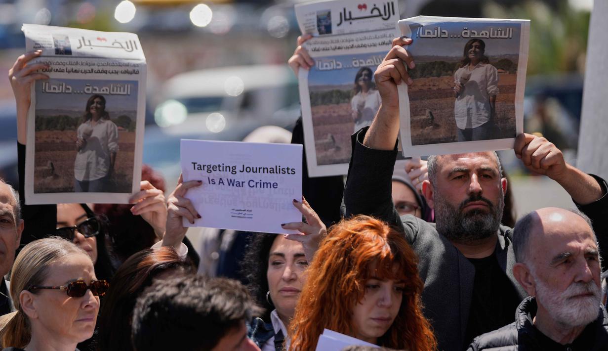 Seorang jurnalis foto, Zeinab Faraj yang merupakan rekan Amal Khalil, dilaporkan terluka dalam insiden serangan Israel ini. Tampak dalam foto, para jurnalis mengangkat koran yang menampilkan potret jurnalis Lebanon Amal Khalil yang tewas dalam serangan udara Israel pada Rabu 22 April 2026, selama aksi duduk menentang penyerangan terhadap jurnalis di Beirut, Lebanon, Kamis 23 April 2026. (AP Photo/Hussein Malla)