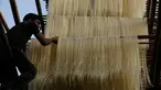Pekerja India menggantung helai bihun untuk dikeringkan di sebuah pabrik di Ahmadabad pada 16 Mei 2019. Bihun sangat diminati di kalangan muslim India karena merupakan menu favorit yang kerap disuguhkan saat berbuka puasa bersama dengan buah-buahan manis. (AP Photo/Ajit Solanki)