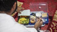 Jemaah makan dalam kamp saat melaksanakan rangkaian ibadah haji di Kota Suci Makkah, Arab Saudi, Kamis (30/7/2020). Hanya sekitar seribu jemaah yang diizinkan untuk melakukan ibadah haji tahun ini karena pandemi COVID-19. (Saudi Ministry of Media via AP)