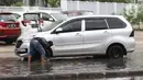 Pengendara memanfaatkan genangan air untuk mencuci kendaraan di Jalan HBR Motik Kemayoran, Jakarta, Selasa (25/2/2020). Hujan yang mengguyur Jakarta sejak Senin (24/2) malam membuat sejumlah kali meluap dan menyebabkan banjir. (Liputan6.com/Helmi Fithriansyah)
